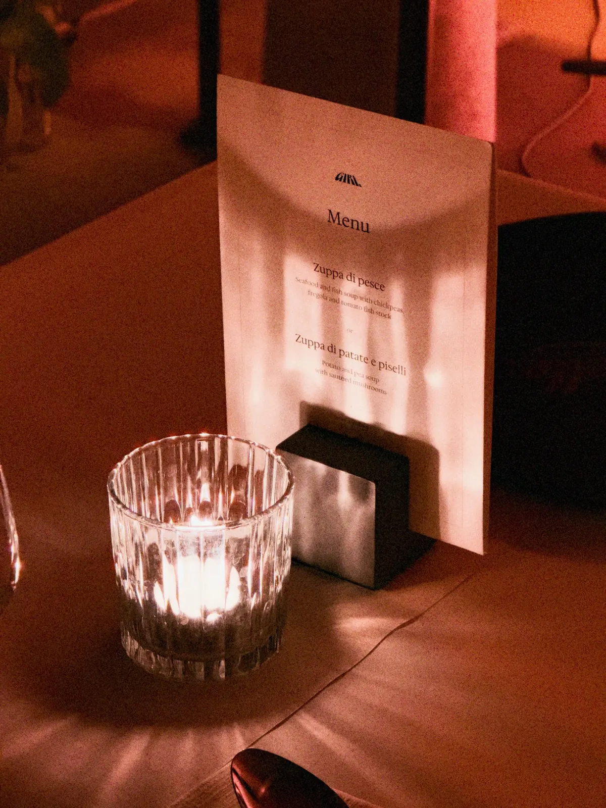 Ein Dinnermenü und eine Kerze im Glas